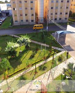 Una vista de un parque con árboles y una furgoneta amarilla en Hotel Garden, en Santa Maria