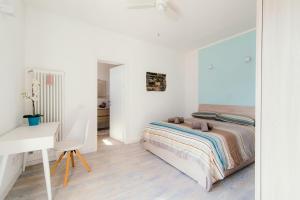Habitación blanca con cama y escritorio en "Gioiello Vista Lago" Moltrasio Lake Como, en Moltrasio