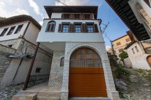 uma casa com uma porta de madeira em frente em Heraklis Hotel em Berati