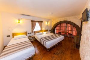 een hotelkamer met 2 bedden en een raam bij Heraklis Hotel in Berat