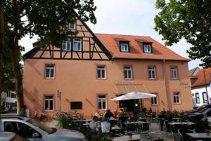 een groot gebouw met tafels en stoelen ervoor bij Hotel-Restaurant 1735 in Speyer