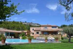 a villa with a swimming pool and a house at Le Bouquet de l Aromate in Joucas