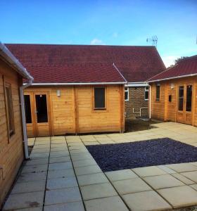 a house with a wooden garage with a driveway at Forest Edge Motel in Ticehurst