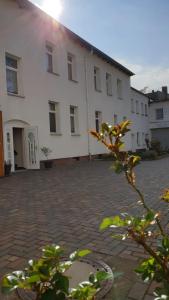 un gran edificio blanco con un patio de ladrillo en Ferienwohnung Halle, en Halle an der Saale