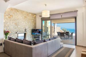 a living room with a couch and a stone wall at VILLA KIVIS in Kivérion
