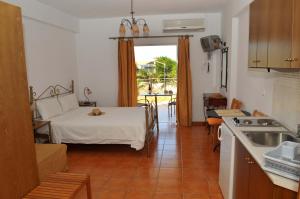 a room with a bed and a kitchen with a table at Kasimis in Kyparissia