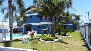 a house with statues of animals in front of a yard at HOTEL MAGIA DO MAR in Capão da Canoa