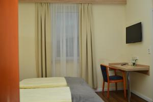 Una habitación de hotel con una cama, un escritorio y un televisor. en Hotel Zur Stadt Cassel, en Neukirchen 9 fotos más