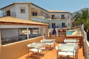 a balcony with tables and chairs and a swimming pool at Kasimis in Kyparissia