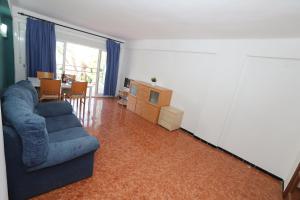 een woonkamer met een blauwe bank en een televisie bij COSTA DAURADA APARTAMENTS - Pompeyo in Cambrils
