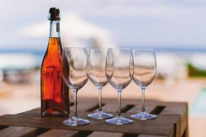 un grupo de copas de vino y una botella en una mesa en Shanalulu Sands - full inverter, en Wilderness
