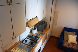 a small kitchen with a stove and a microwave at Cozy Garden Retrait in Varenna