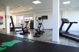 een fitnessruimte met loopbanden en hometrainers in een kamer bij RIDE Surf Resort & Spa in Peniche