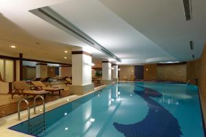 a swimming pool in a hotel with a lobby at Byotell Hotel Istanbul in Istanbul