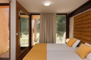 a bedroom with a large bed with yellow pillows at Casa do Sobreiro in Pedroso +16 photos