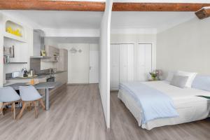 a bedroom with a bed and a table and a kitchen at My rima in Antibes