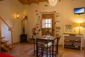 モンシケにあるQuinta do Tempo Turismo Ruralのテーブル、椅子、テレビが備わる客室です。