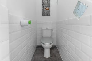 a bathroom with a toilet in a white tiled room at My rima in Antibes