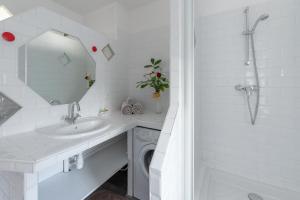 a white bathroom with a washing machine and a sink at My rima in Antibes