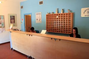 a woman is sitting at a counter in a practition at La Mitica 99 del Portolaconia Residence in Cannigione