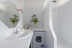 a white bathroom with a washing machine and a sink at My rima in Antibes