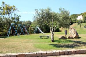 un parc avec une balançoire et une aire de jeux dans l'établissement La Mitica 99 del Portolaconia Residence, à Cannigione
