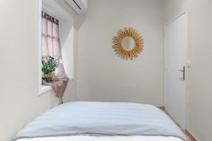 a white bedroom with a bed and a mirror at My rima in Antibes