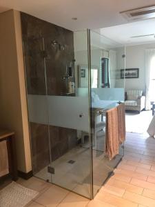 a glass shower in a room with a bathroom at Eden Island Gem in Eden Island