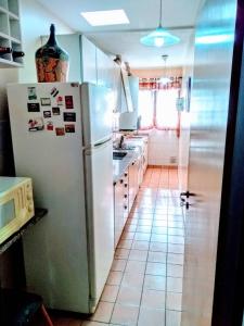 a kitchen with a white refrigerator and a tile floor at Bombal Departamentos in Mendoza