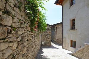 een stenen muur met bloemen naast een gebouw bij Ca de l'Angelon - Apartment Sardella in Brenzone sul Garda