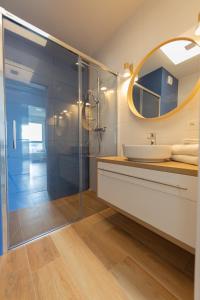 a bathroom with a sink and a glass shower at Baltic Apartments Seaside Towers in Gdańsk