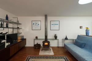 a living room with a blue couch and a fireplace at Casa do Sobreiro in Pedroso