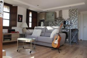 - un salon avec un canapé et une guitare dans l'établissement Morente sueña La Alhambra, à Grenade