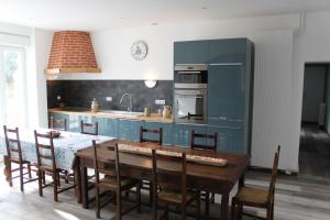 een keuken met een houten tafel en een blauwe kast bij Domaine de Praline l'ensemble in Villerbon