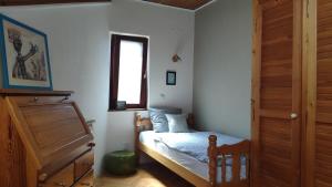 a small bedroom with a bed and a window at Fedra Apartment in Zrenjanin