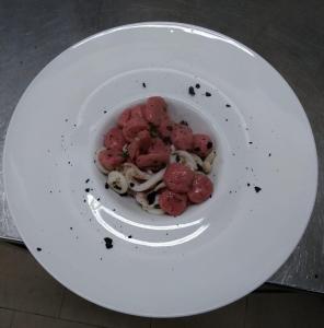 une assiette blanche avec un bol de nourriture sur une table dans l'établissement Locanda Corte Arcangeli, à Ferrare