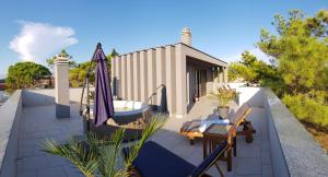 a patio with an umbrella and a table on a roof at CUBE apartments in Vir