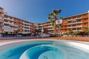 une piscine vide en face d'un hôtel dans l'établissement Balcon de Los Gigantes 2A037, à Puerto de Santiago