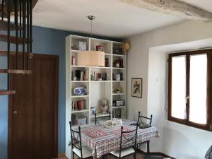 a dining room with a table and a book shelf at Appartamento Orta centro in Orta San Giulio