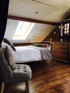 a bedroom with a bed and a chair and a window at Victorian Penthouse Apartment in Gloucester