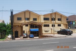a building on the side of a street with cars parked outside at Ampomaah Hotel in Accra