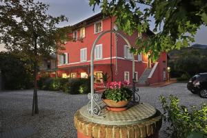 un grande edificio rosso con una pentola di fiori davanti di In Versilia a Seravezza