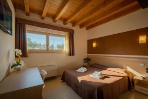 a hotel room with two beds and a window at Agriturismo Tre Colline in Bardolino