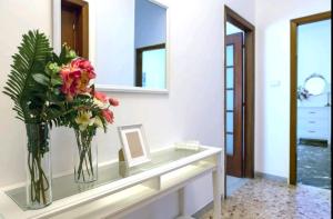 un jarrón de flores sentado en un mostrador en una habitación en La casetta di Ilma, en Vietri 8 fotos más