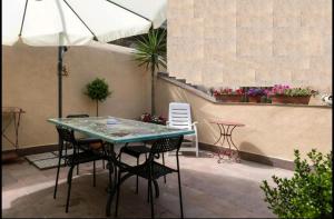 a patio with a table and chairs and an umbrella at La casetta di Ilma in Vietri sul Mare