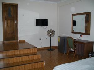 um quarto com escadas, uma secretária e uma televisão em Ampomaah Hotel em Acra