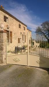 um portão em frente a um edifício com uma casa em Le Petit Logis em Puy-du-Fou