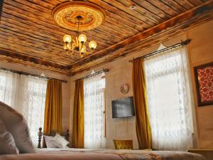 a bedroom with two windows and a chandelier at Caravanserai Inn Hotel in Göreme