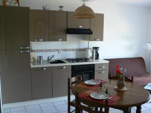 een keuken met een houten tafel en een keuken met een fornuis bij Gîte la Sapinière in Labaroche