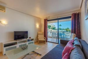 un salon avec un canapé et une télévision dans l'établissement Balcon de Los Gigantes 2A037, à Puerto de Santiago